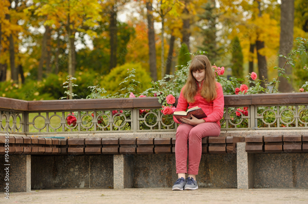 Girl is sitting on bench and reading book, autumn. Girl is sitting on bench and reading book, autumn.