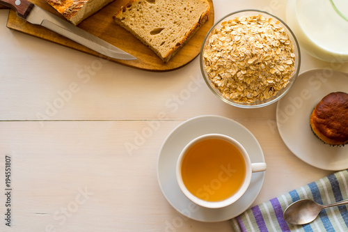 Healthy breakfast. Oatmeal, tea and fresh pastries - copy space, top view. Natural lighting