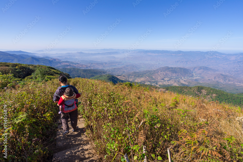 Doi Inthanon National Park, The hill tribe carrying a child walk on the top highest mountain of Thailand