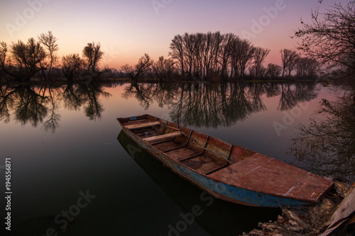 Fototapeta Naklejka Na Ścianę i Meble -  Vibrant wide angle landscape panorama with lonely boat in sunset in fall
