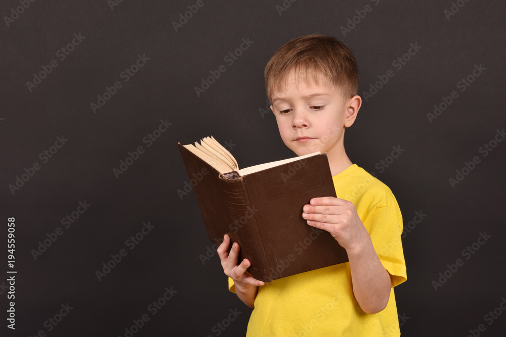 A boy with books. A schoolboy teaches lessons. Shooting in a studio. A child in a yellow T-shirt. A smart person. A commitment to knowledge. A boy with books. A schoolboy teaches lessons. Shooting in a studio. A child in a yellow T-shirt. A smart person. A commitment to knowledge.