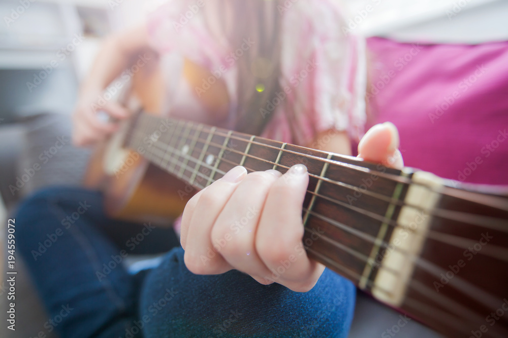 Female hands playing acoustic guitar