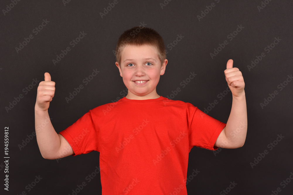 Portrait of a boy on a black background. The child has a good mood. A man in a red T-shirt. Portrait of a boy on a black background. The child has a good mood. A man in a red T-shirt.