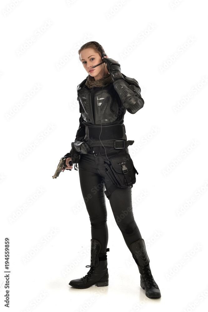 full length portrait of female soldier wearing black tactical armour, holding a gun, isolated on white studio background. full length portrait of female soldier wearing black tactical armour, holding a gun, isolated on white studio background.