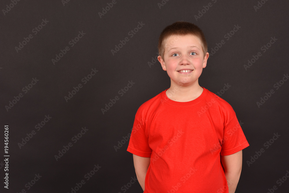 Portrait of a boy on a black background. The child has a good mood. A man in a red T-shirt. Portrait of a boy on a black background. The child has a good mood. A man in a red T-shirt.
