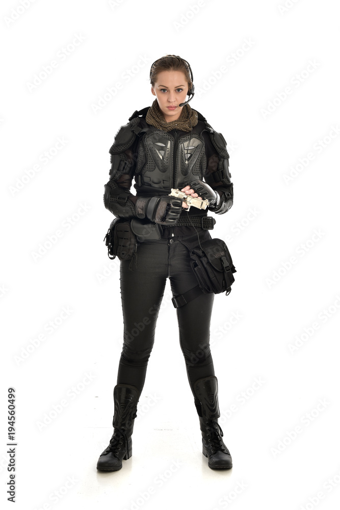 full length portrait of female soldier wearing black tactical armour, holding a gun, isolated on white studio background. full length portrait of female soldier wearing black tactical armour, holding a gun, isolated on white studio background.