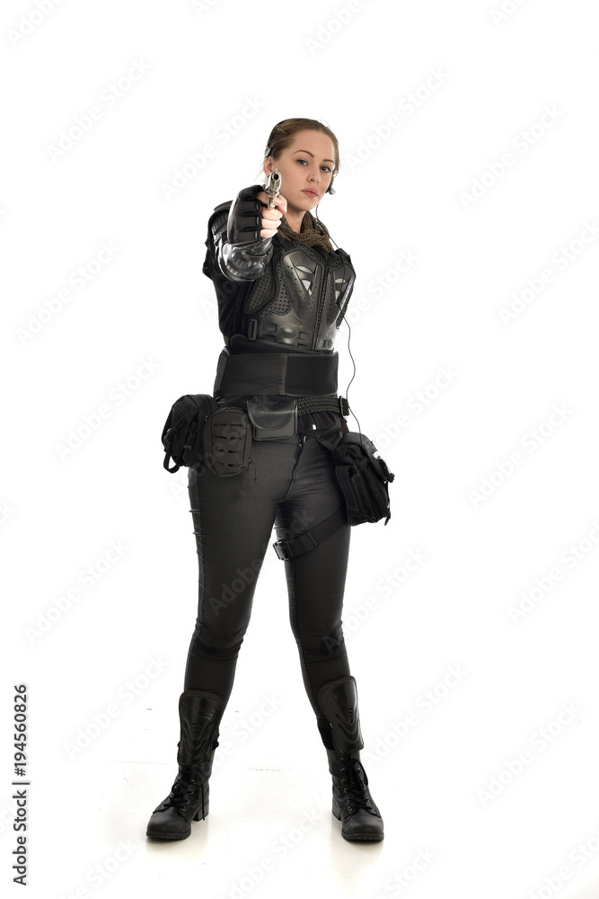 full length portrait of female soldier wearing black tactical armour, holding a gun, isolated on white studio background. full length portrait of female soldier wearing black tactical armour, holding a gun, isolated on white studio background.