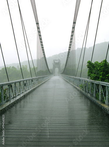 Sainte Rose / La Reunion: The magnificent and impressive old suspension bridge over the East River on a rainy day in January photo