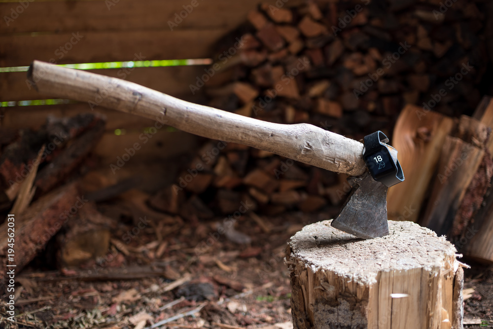 Smartwatch on the ax. The ax in the stump. Firewood. Chopping wood. Smartwatch on the ax. The ax in the stump. Firewood. Chopping wood.