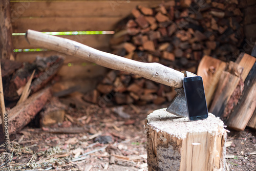Smartphone on the stump. Smartphone near the ax. The ax in the stump. Firewood. Chopping wood.
