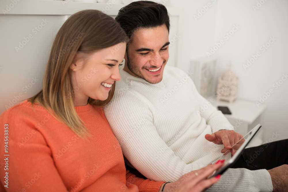 Young couple using tablet laughing Young couple using tablet laughing