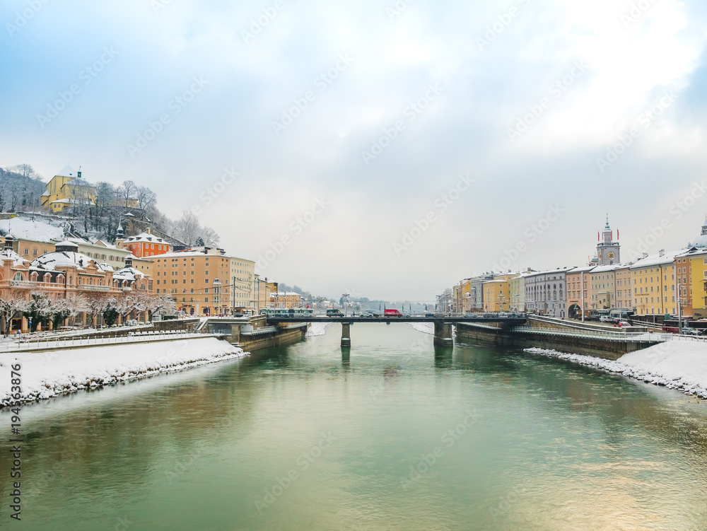 Landscape view winter snow season blue sky green river bridge in Salzburg.