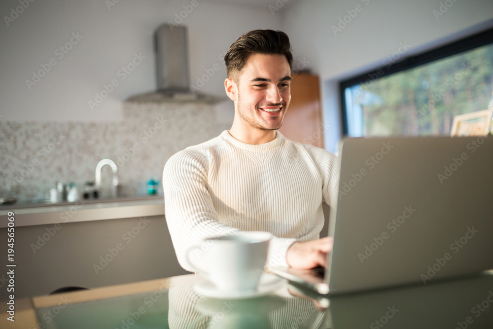 Young happy man working at home on laptop Young happy man working at home on laptop