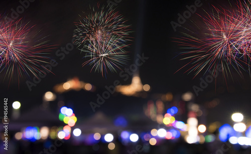 Colorful fireworks explosion with aerial view of buddha temple on the mountain background