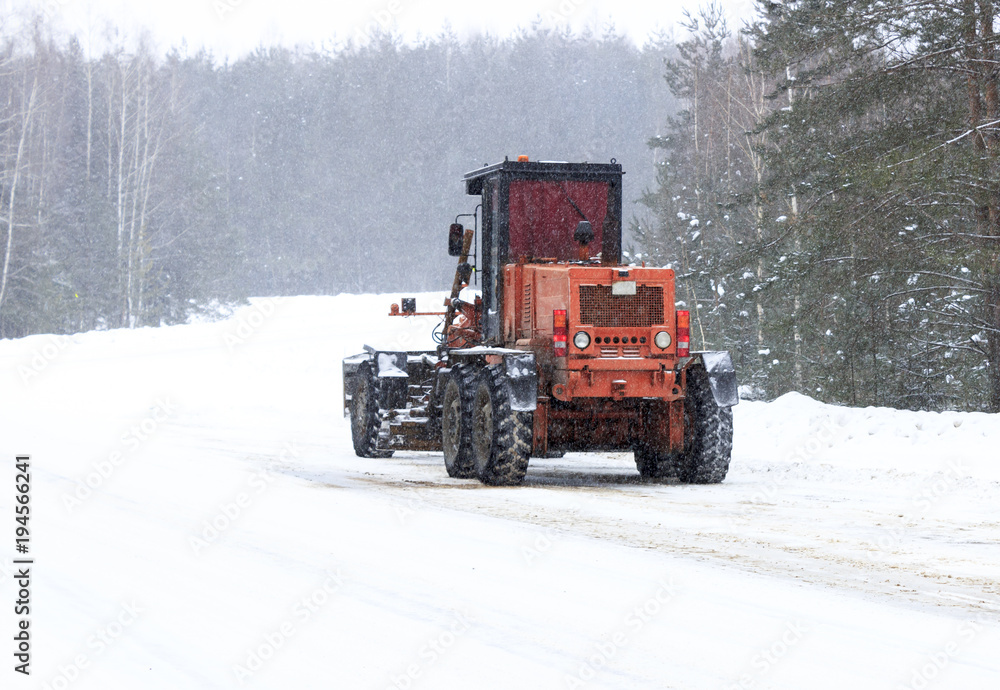Winter. Snowing. The tractor clears the snow from the road. Winter. Snowing. The tractor clears the snow from the road.