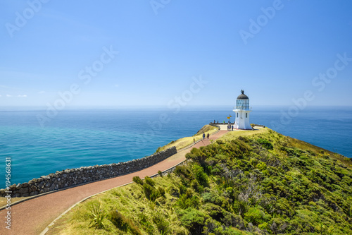 Stunning wide angle view of Cape Reinga Lighthouse and the path leading to it at Cape Reinga, the northernmost point of the North Island of New Zealand. The lighthouse is a famous tourist attraction.