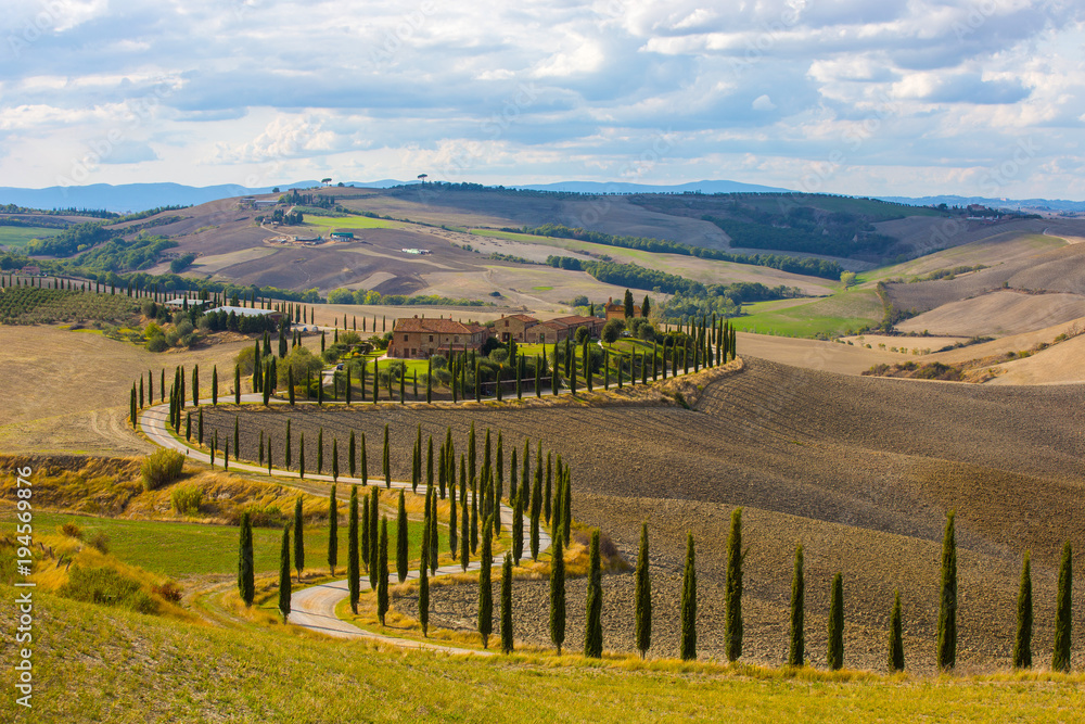 Landscape of hills, country road, cypresses trees and rural houses,Tuscany , rural Italy
