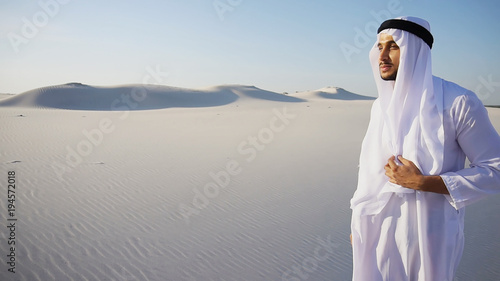 Εκτύπωση καμβά Smart handsome emirate Arabian UAE Sheikh businessman prints on computer keyboard and answers incoming phone call from business partner or client, communicates about building in desert