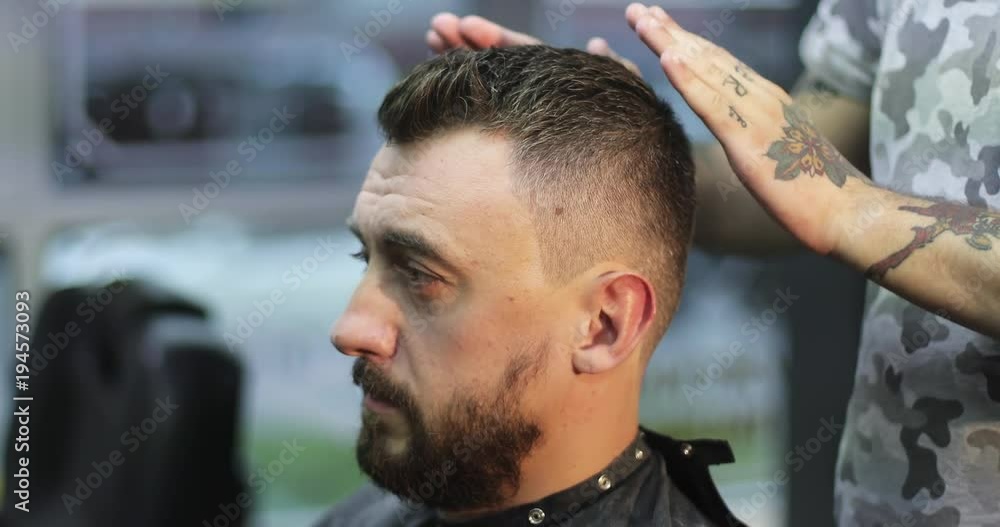 Hairdresser is applying gel on the hair of customer in barbershop. Hairdresser is applying gel on the hair of customer in barbershop.
