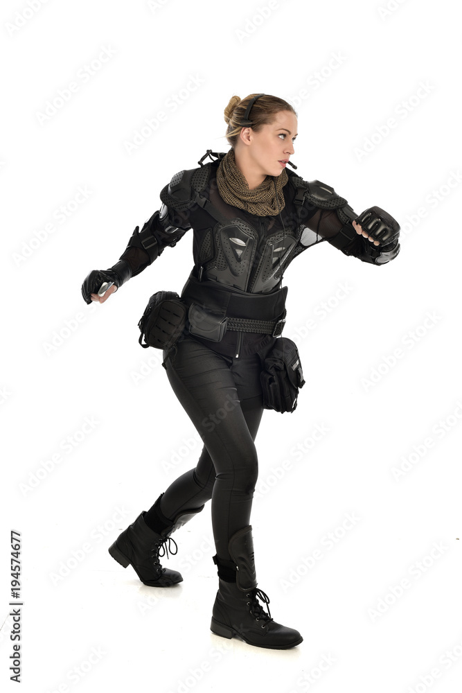 full length portrait of female soldier wearing black tactical armour, holding a remote knife, isolated on white studio background. full length portrait of female soldier wearing black tactical armour, holding a remote knife, isolated on white studio background.