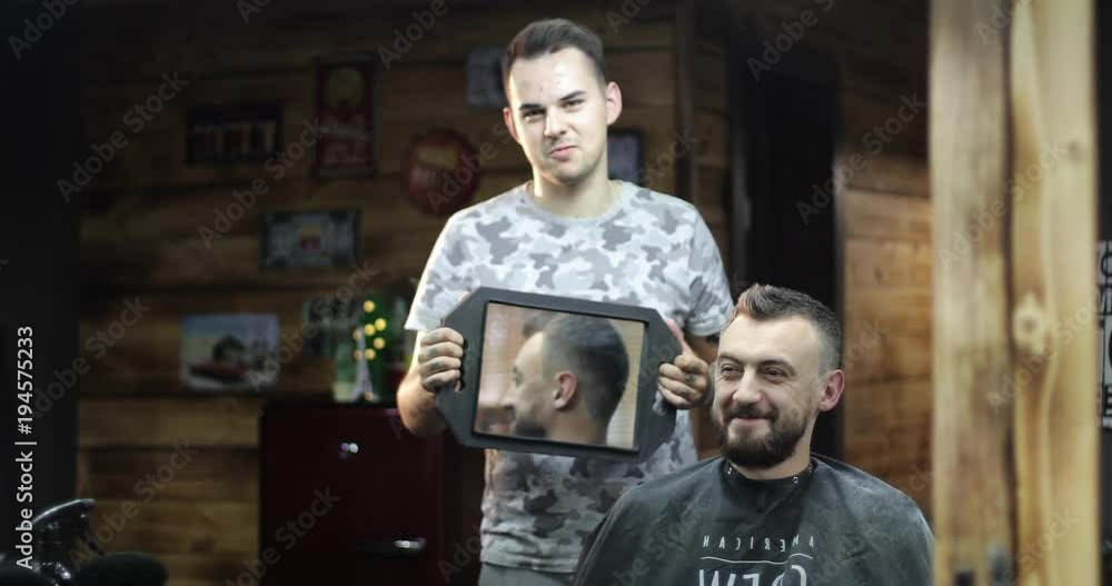 Hairdresser is showing client new haircut using mirror. Hairdresser is showing client new haircut using mirror.