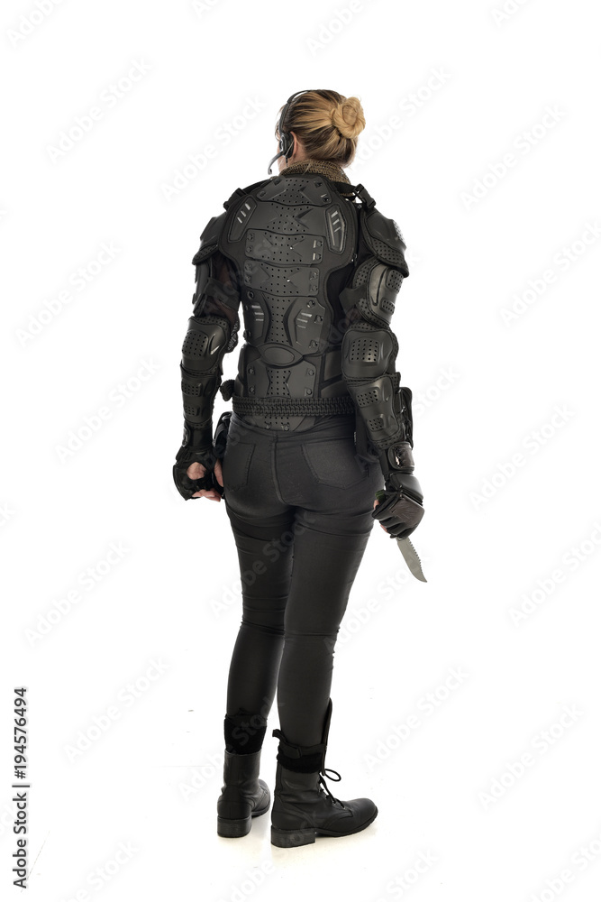 full length portrait of female soldier wearing black tactical armour, holding a remote knife, isolated on white studio background. full length portrait of female soldier wearing black tactical armour, holding a remote knife, isolated on white studio background.