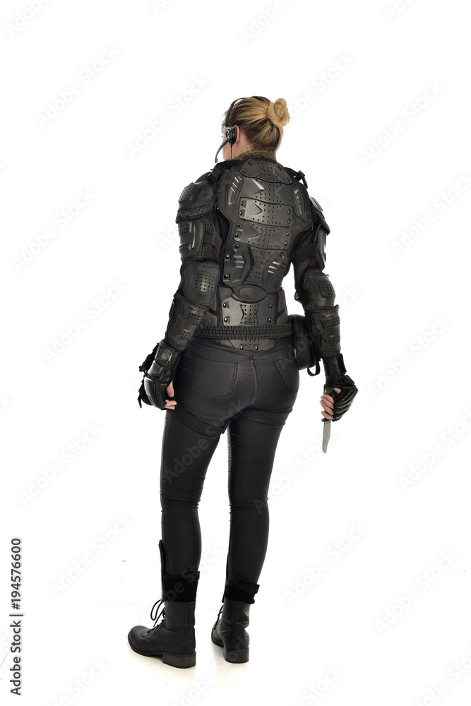 full length portrait of female soldier wearing black tactical armour, holding a remote knife, isolated on white studio background. full length portrait of female soldier wearing black tactical armour, holding a remote knife, isolated on white studio background.