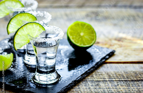 Fényképezés Bar set with shots, fresh lime and salt on wooden background