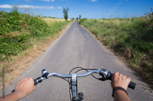 Rider driving bicycle on an asphalt road.