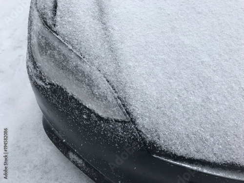 Фотография Front of parked car close up of headlight in cold snow weather
