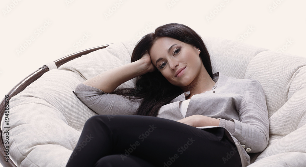Fototapeta premium young woman sitting in a comfortable soft big armchair