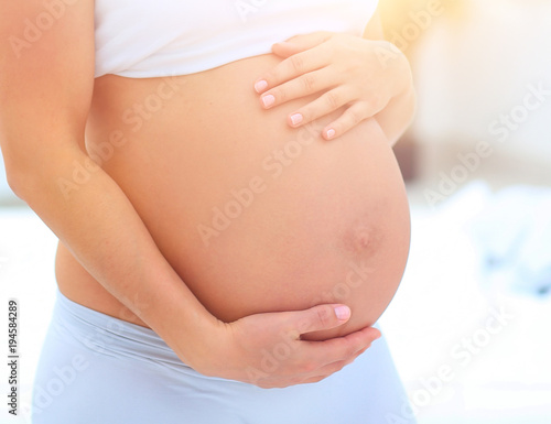 portrait of young pregnant woman on a light background.