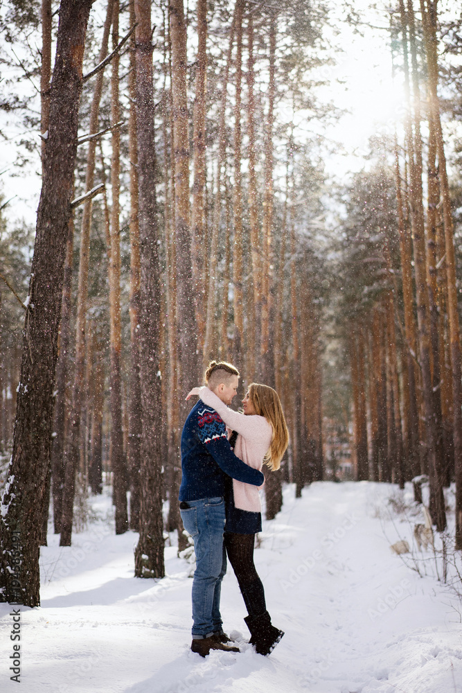 full length view of happy young couple hugging in winter forest