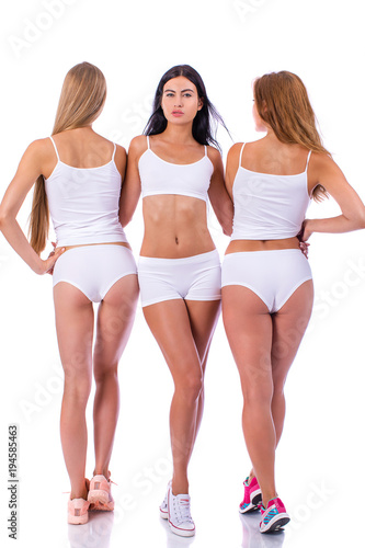 Fitness women. Three young beautiful girlfriends in white sportswear