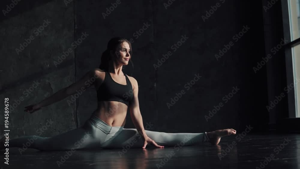 girl doing stretching sitting on a string. gymnast for training. attractive young woman in sportswear is engaged in yoga. girl doing stretching sitting on a string. gymnast for training. attractive young woman in sportswear is engaged in yoga.