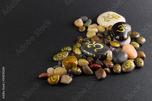 Pile of little decorative stones painted with Om symbol