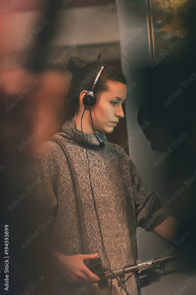 Naklejka premium Behind the scene. Female cameraman shooting film scene with camera