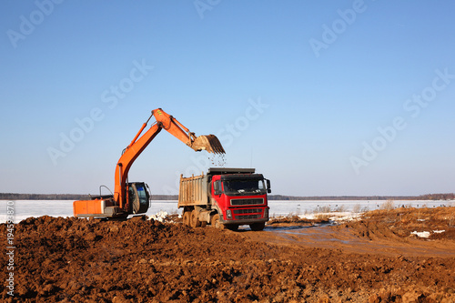 Construction of moorings for the parking of boats - Excavator behind and dump truck work