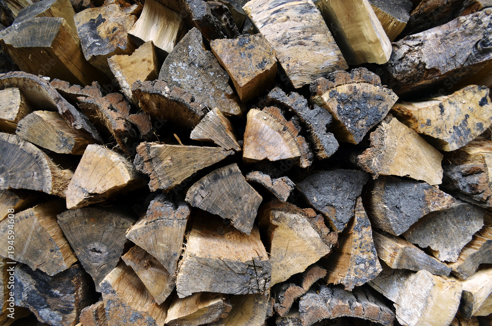 Detailed view to stacked and seasoned firewood for an open-hearth fireplace Detailed view to stacked and seasoned firewood for an open-hearth fireplace