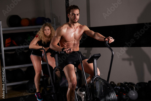 people workout at fitness club - air bike 