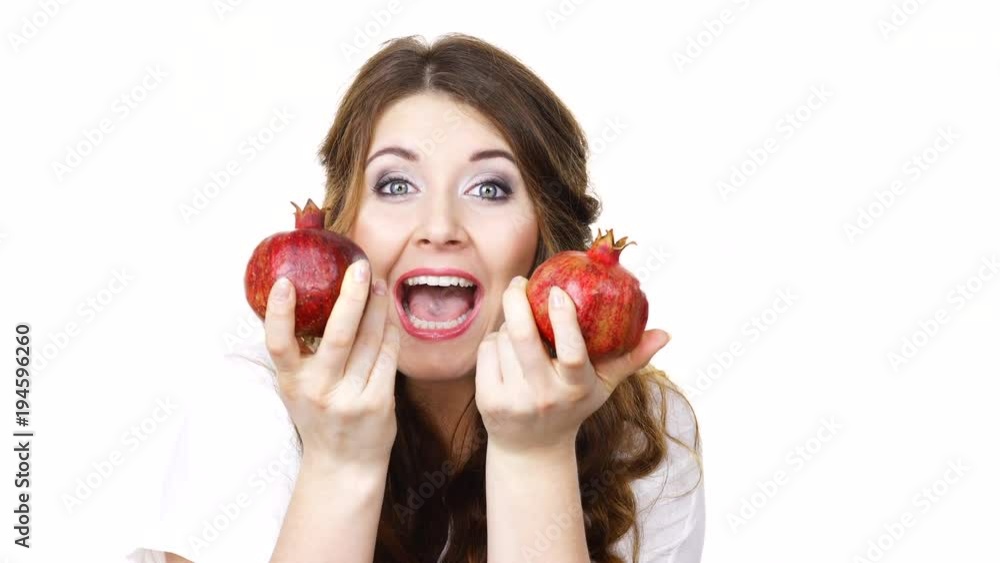 Woman cheerful brunette girl holding pomegranate fruits in hands, isolated on white. Healthy eating, cancer prevention, immune support. Woman cheerful brunette girl holding pomegranate fruits in hands, isolated on white. Healthy eating, cancer prevention, immune support.