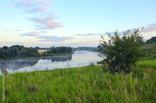 Summer landscape with river.Green hills,fields and meadows.River Krasivaya in Tula region,Russia.Sunrise.Quiet morning.Calm.Twilight.Beautiful clouds in blue sky.Fog on the water. photo