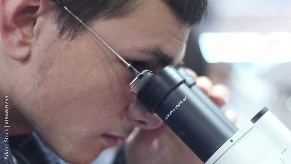 man looks professional scientific microscope. man looks professional scientific microscope.