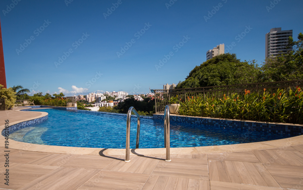 Infinity pool with trees and buildings in the background