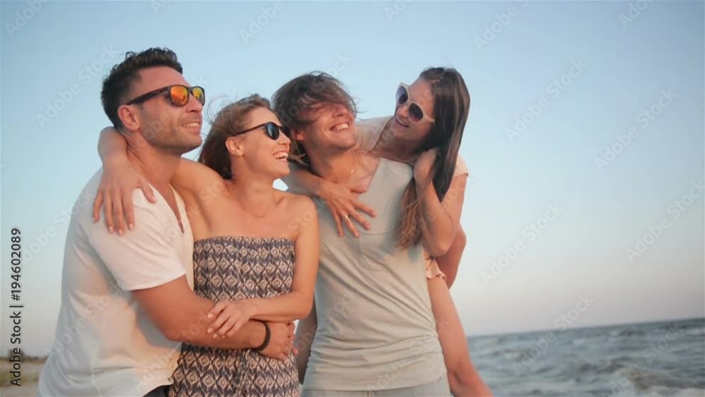 Portrait of Four Friends Having Fun Together on the Seaside during Windy Weather and Enjoying the Sunset. Portrait of Four Friends Having Fun Together on the Seaside during Windy Weather and Enjoying the Sunset.