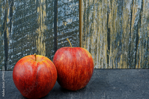 Two red apples on an old stone worktop