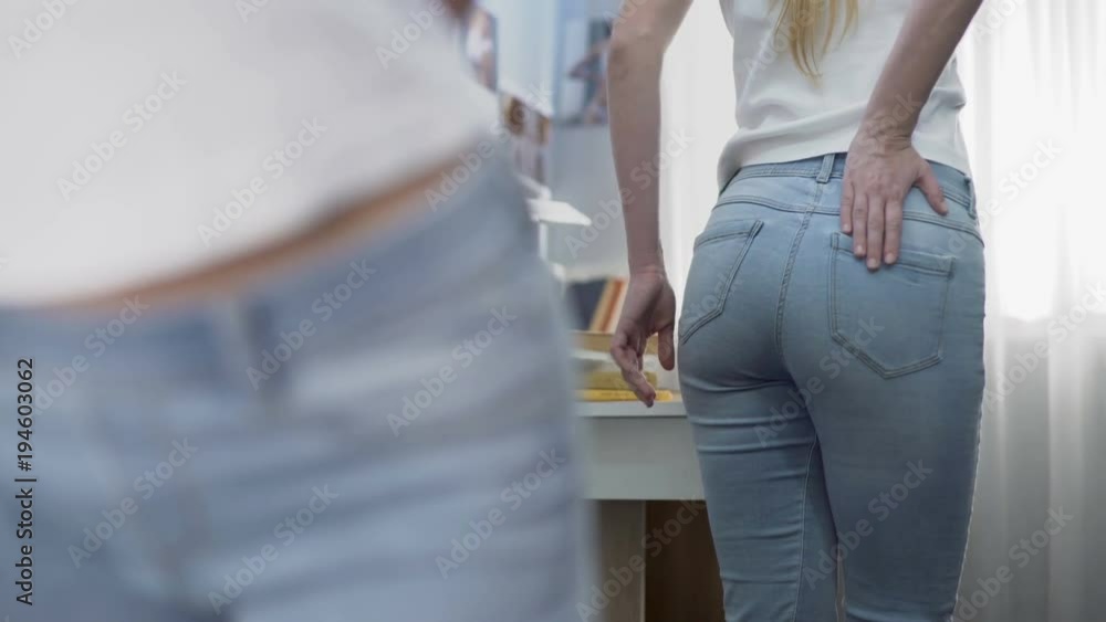 Upset school girl turning around in front of big mirror, negative self identity Upset school girl turning around in front of big mirror, negative self identity
