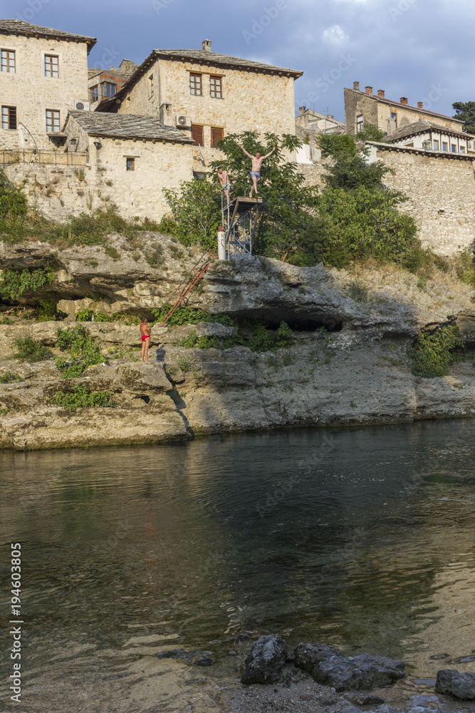 MOPeople diving into Neretva river in Mostar at sunset time