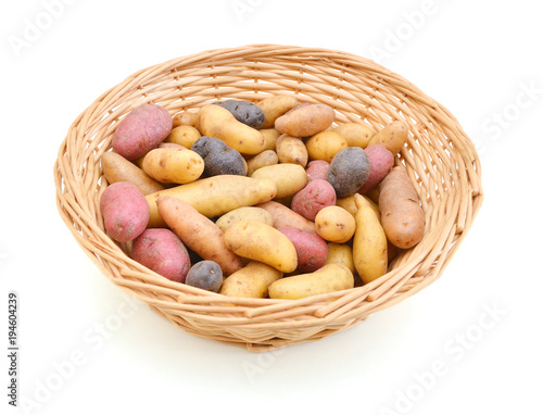 Canvas-taulu Fresh colorful potatoes red white blue in basket on white background