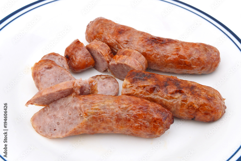 Grilled bratwurst in white plate on white background Grilled bratwurst in white plate on white background